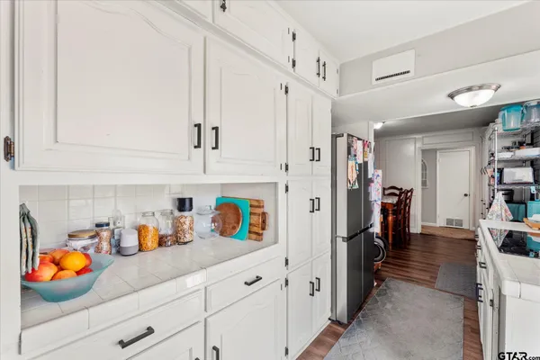 a bathroom with a granite countertop sink a toilet and a mirror