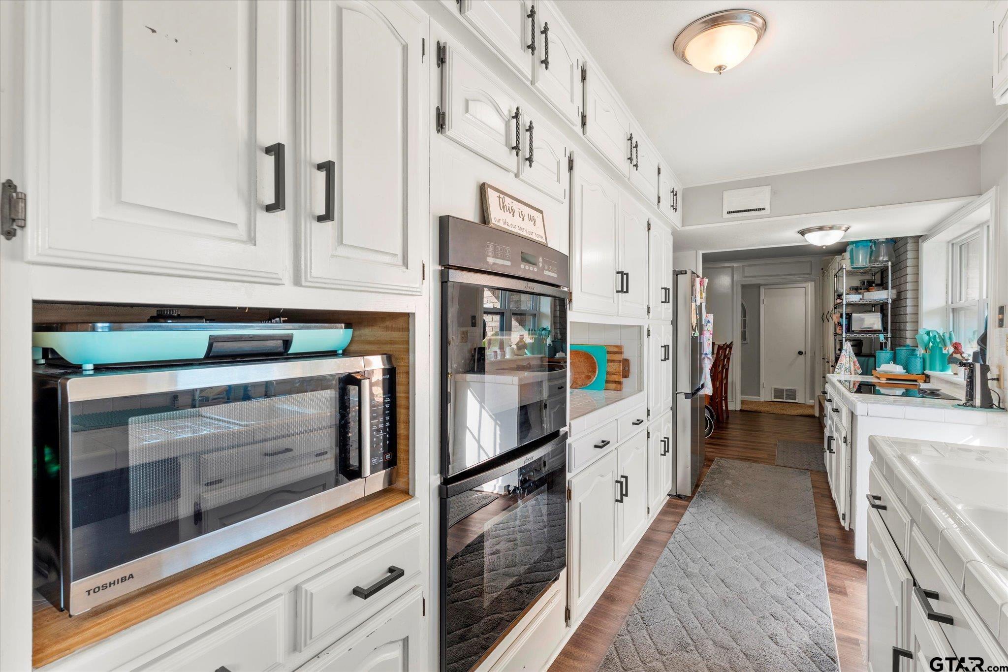 337 Daingerfield Street Pittsburg, TX 75686 - Photo 21 of 40 a kitchen with stainless steel appliances white cabinets and a window