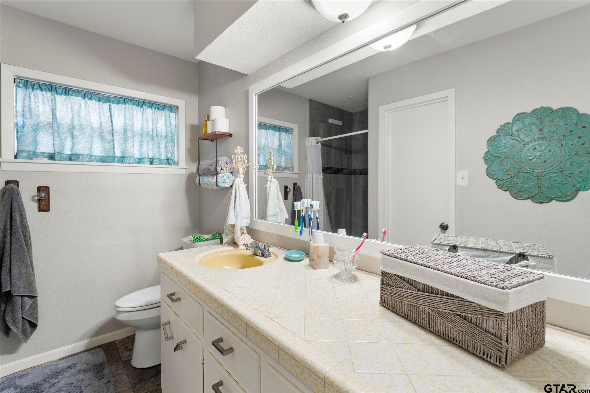 337 Daingerfield Street Pittsburg, TX 75686 - Photo 25 of 40 a bathroom with a granite countertop sink a toilet and a mirror