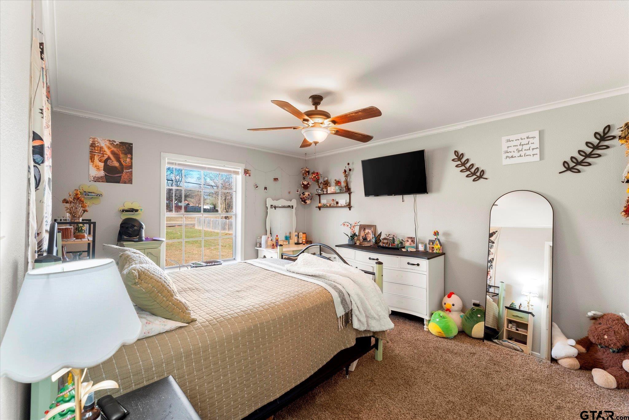 337 Daingerfield Street Pittsburg, TX 75686 - Photo 29 of 40 a bedroom with bed a couch and a large window