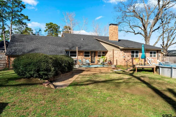 a view of a house with pool and chairs