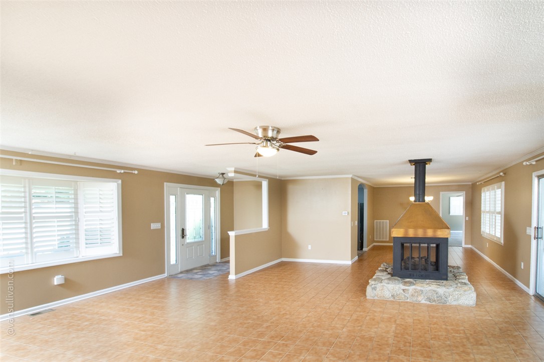 4518 Cove Trail Anderson, SC 29621 - Photo 49 of 49 An open floorplan centers around a freestanding stone fireplace and durable tile flooring.