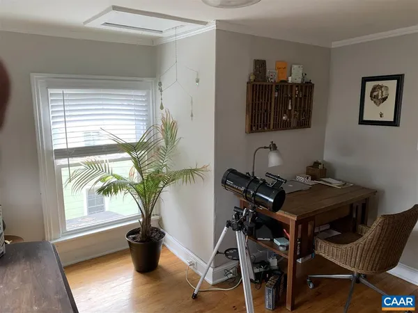 a view of a workspace with furniture and a window