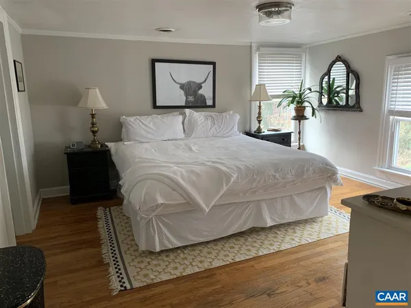 a bedroom with a bed and wooden floor
