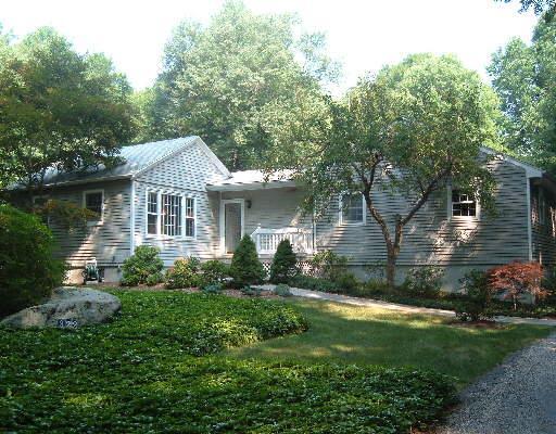 a front view of a house with a yard and green space