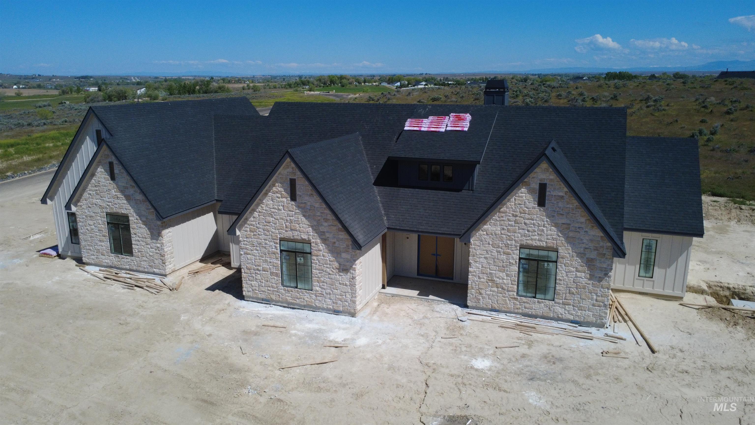 27502 Commerce Comet Way Caldwell, ID 83607 - Photo 2 of 8 Stone and board-and-batten exterior with dark shingle roofing