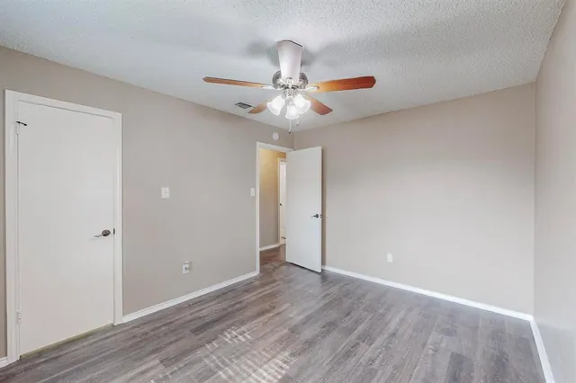 a view of an empty room and chandelier fan