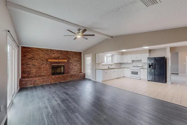 a view of an empty room with a fireplace and a window