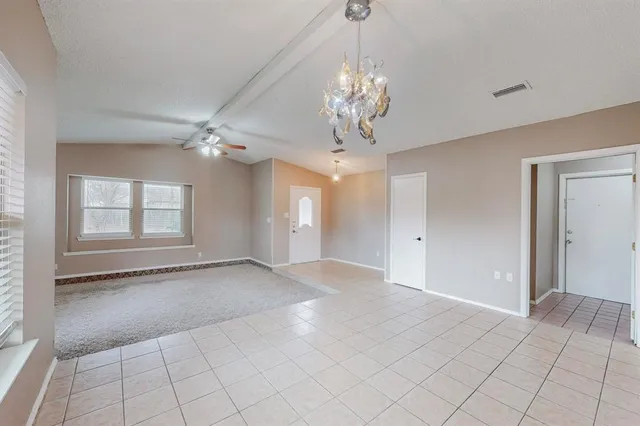 a view of an empty room with chandelier