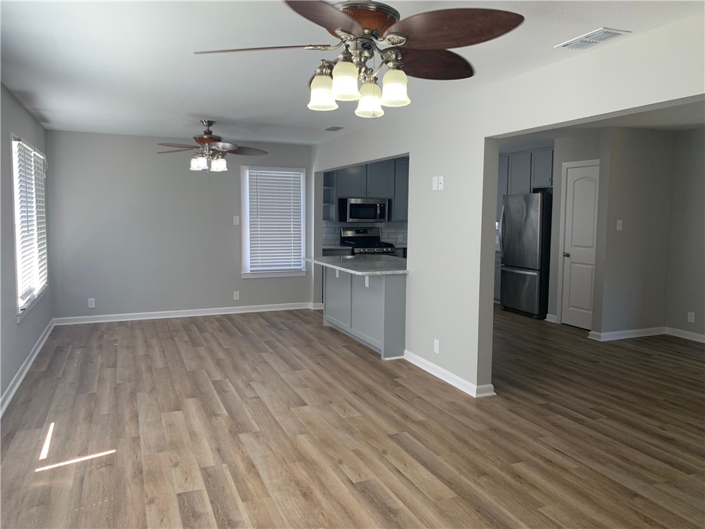 904 Cunningham Street Corpus Christi, TX 78411 - Photo 6 of 16 a view of a kitchen with wooden floor and a ceiling fan