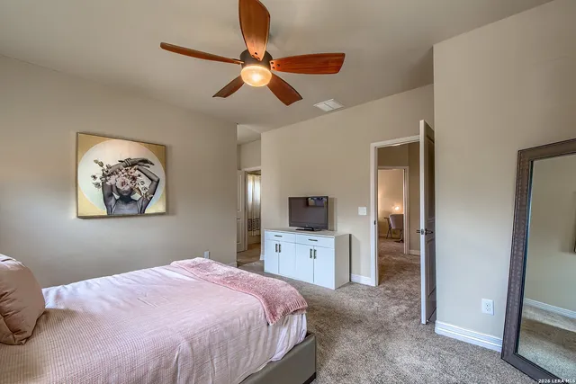 a bedroom with a bed a chair and a chandelier