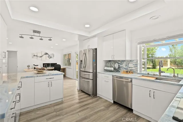 a kitchen with a sink a window and stainless steel appliances
