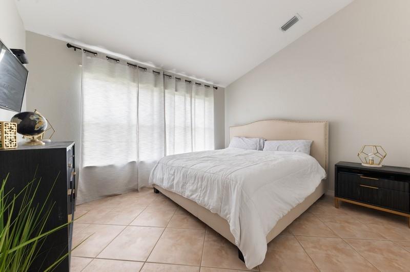 4145 Bluff Harbor Way Wellington, FL 33449 - Photo 11 of 16 a bedroom with a bed and a window