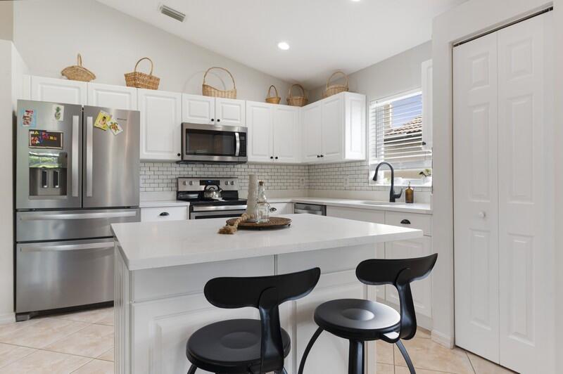 4145 Bluff Harbor Way Wellington, FL 33449 - Photo 2 of 16 a kitchen with stainless steel appliances a sink and a refrigerator