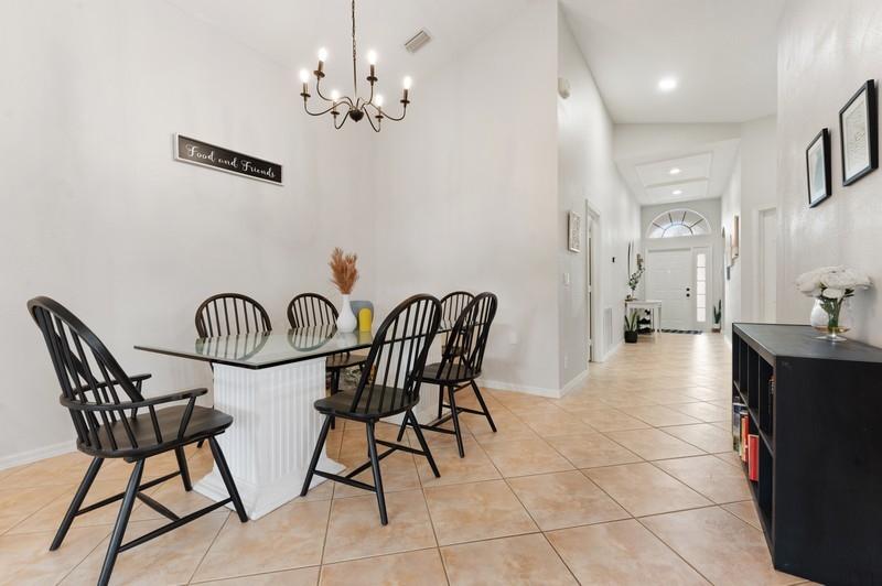 4145 Bluff Harbor Way Wellington, FL 33449 - Photo 3 of 16 a view of a dining room with furniture and a chandelier