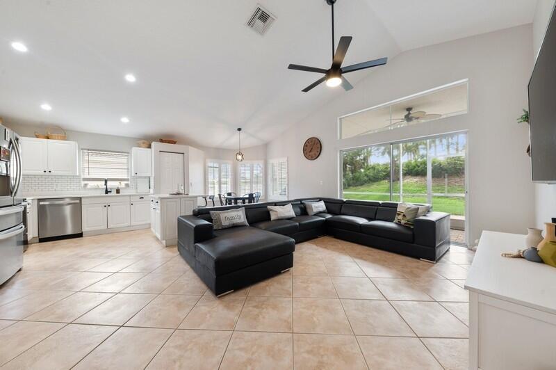4145 Bluff Harbor Way Wellington, FL 33449 - Photo 5 of 16 a living room with couches and kitchen view with wooden floor