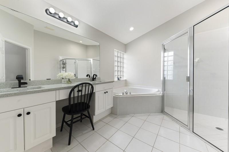 4145 Bluff Harbor Way Wellington, FL 33449 - Photo 8 of 16 a bathroom with a bathtub shower sink a toilet and mirror