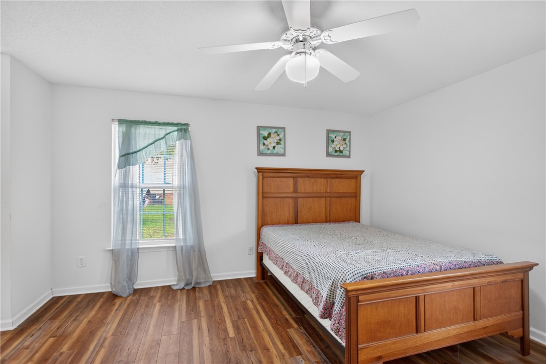 207 Hunters Lane Anderson, SC 29625 - Photo 20 of 46 The primary bedroom features wood flooring, a ceiling fan for year-round comfort, a full bathroom and a large walk-in closet.