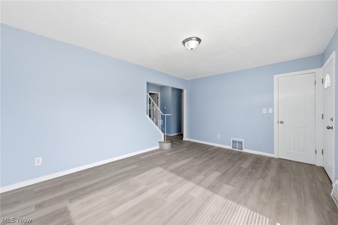 20705 Hansen Road Maple Heights, OH 44137 - Photo 3 of 24 Empty room with stairs and light wood finished floors