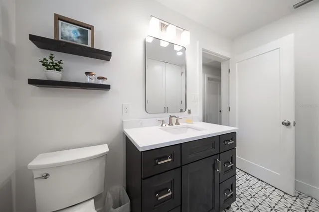 a bathroom with a toilet a sink and mirror