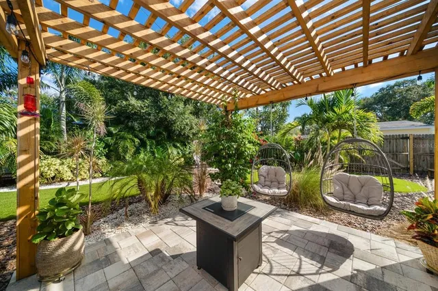 a view of a backyard with table and chairs potted plants