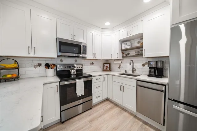 a kitchen with stainless steel appliances granite countertop a stove a sink and a refrigerator