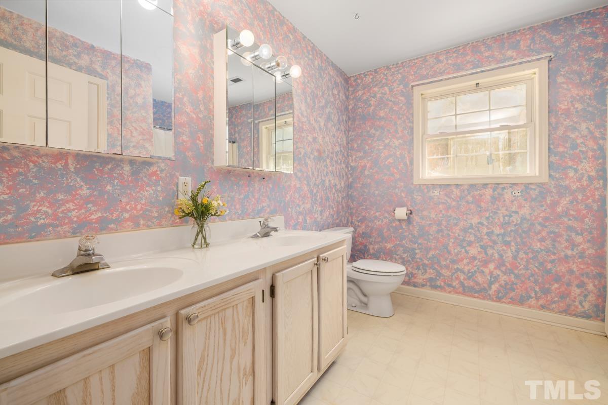 200 Landmark Road Willow Spring, NC 27592 - Photo 21 of 25 a bathroom with a granite countertop sink a toilet and a mirror