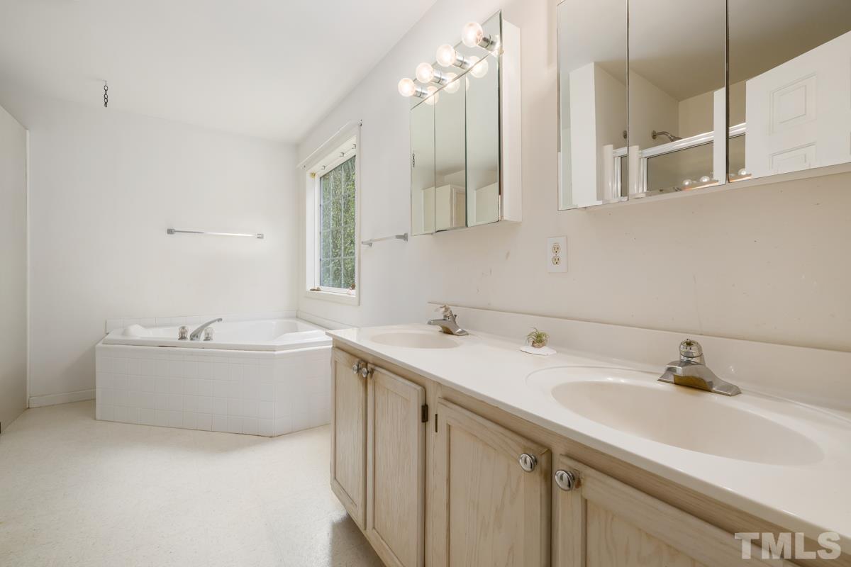 200 Landmark Road Willow Spring, NC 27592 - Photo 10 of 25 a bathroom with a tub sink and mirror