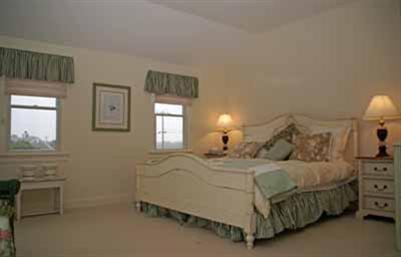 326 Morris Island Road Chatham, MA 02633 - Photo 26 of 34 a bedroom with a bed a chandelier and dresser