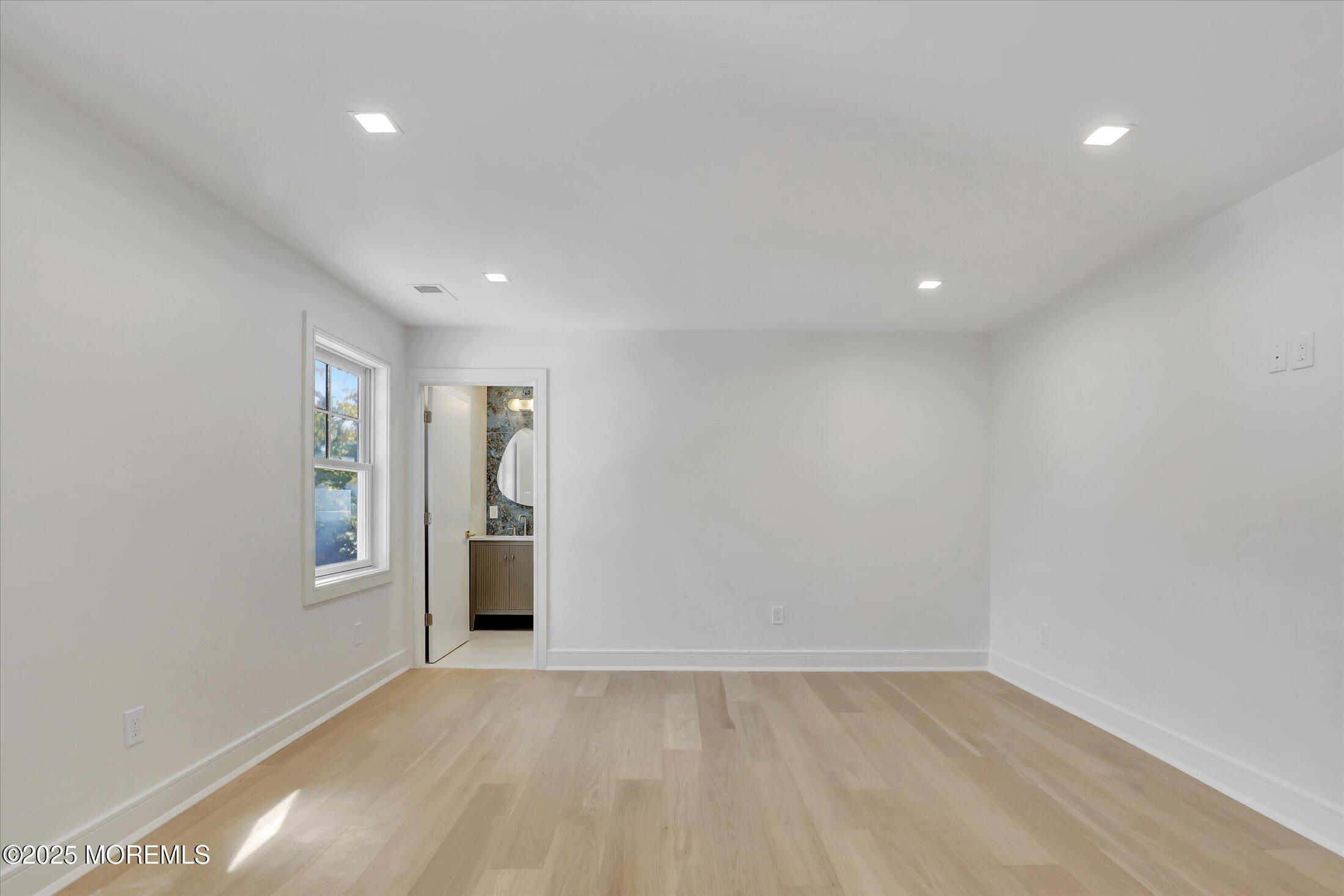 243 Woodcrest Road Oakhurst, NJ 07755 - Photo 23 of 39 a view of an empty room with window and wooden floor