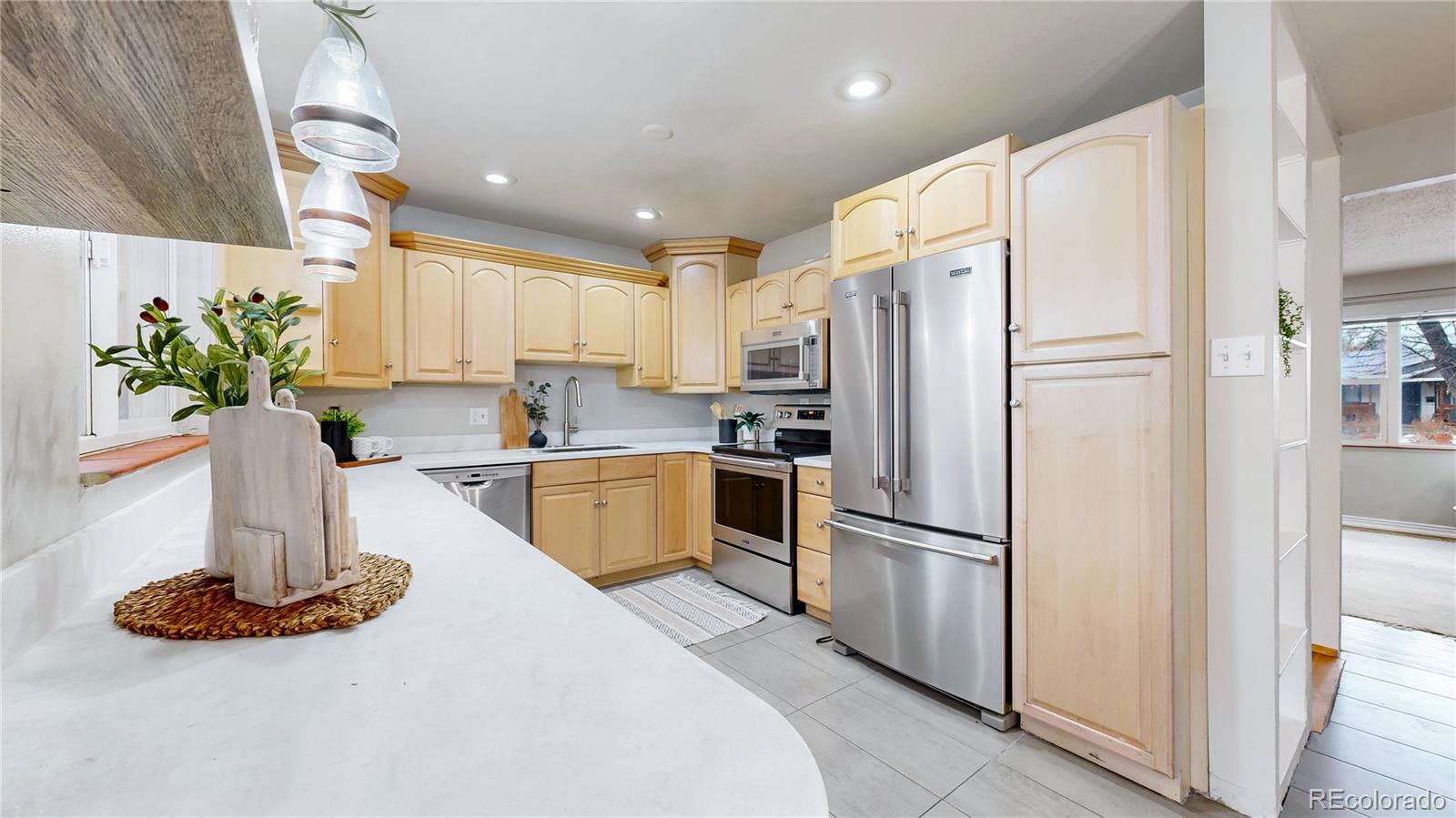 3246 South Stuart Street Denver, CO 80236 - Photo 11 of 43 a kitchen with stainless steel appliances a refrigerator a stove a sink and a microwave
