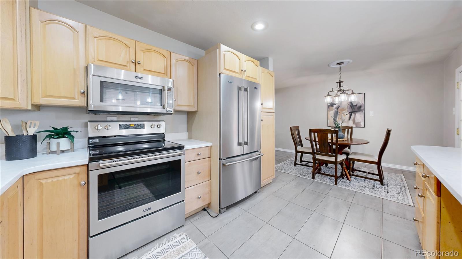 3246 South Stuart Street Denver, CO 80236 - Photo 13 of 43 a kitchen with stainless steel appliances granite countertop a stove a refrigerator and a cabinets