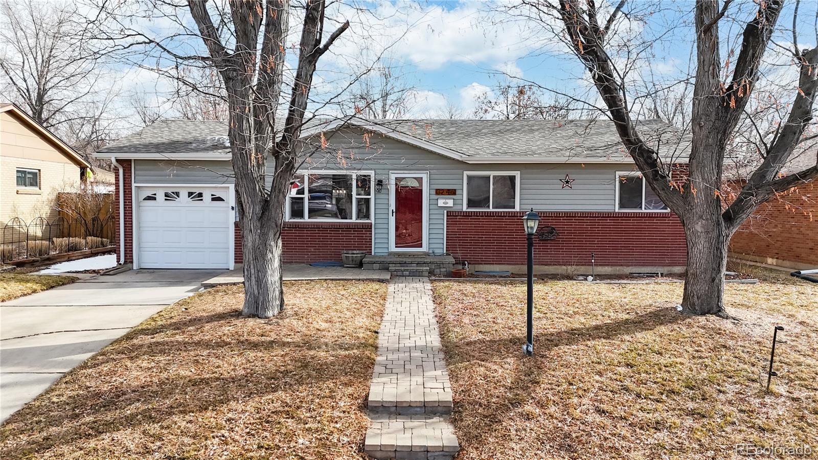 3246 South Stuart Street Denver, CO 80236 - Photo 2 of 43 a front view of a house with a yard and garage