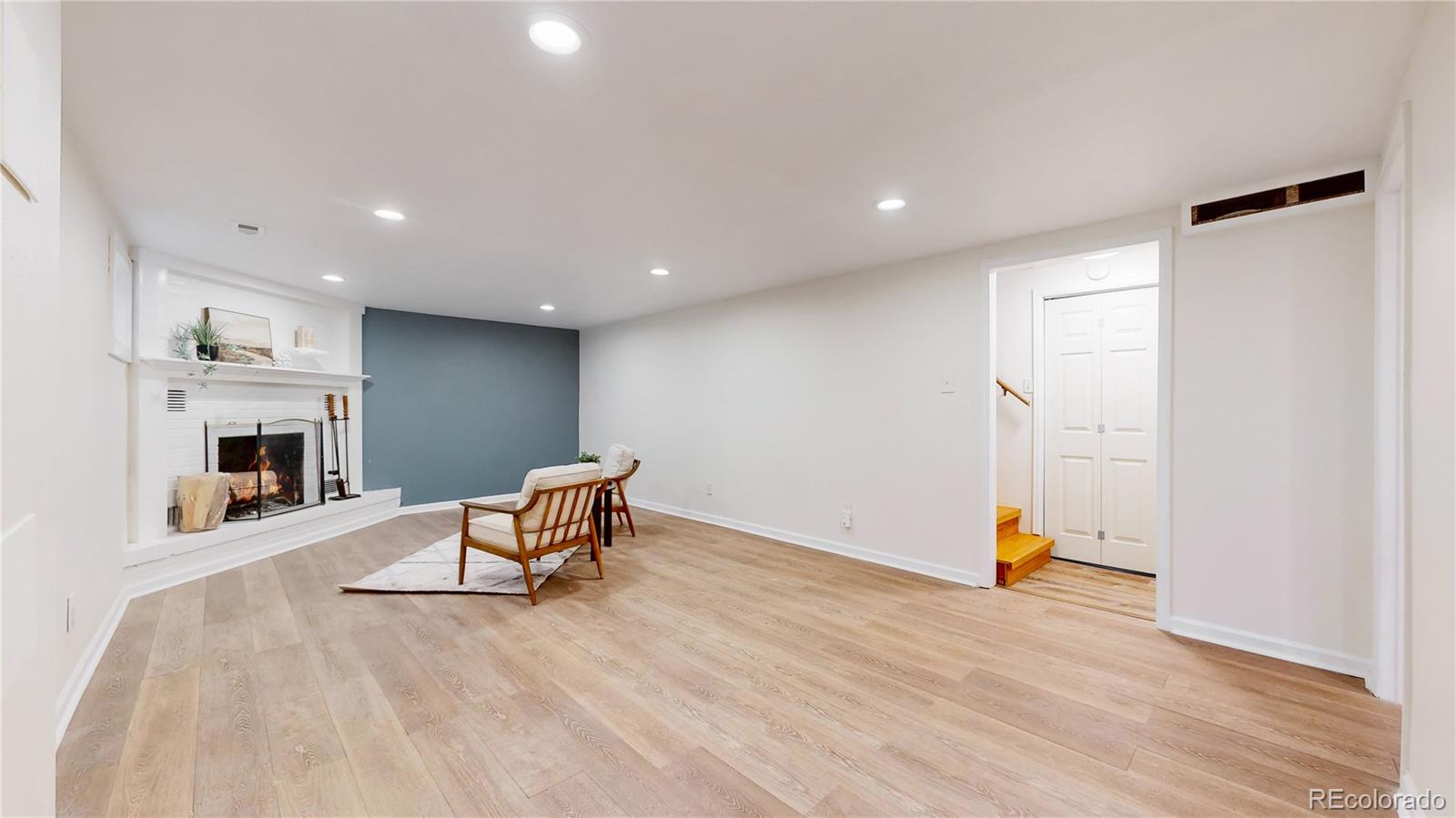 3246 South Stuart Street Denver, CO 80236 - Photo 26 of 43 an empty room with wooden floor and fireplace