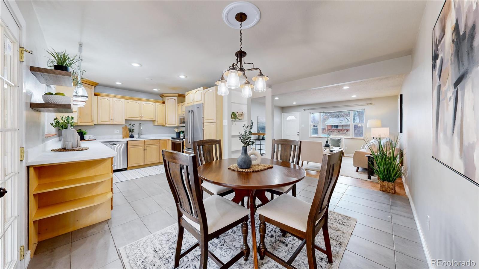 3246 South Stuart Street Denver, CO 80236 - Photo 10 of 43 a dining room with stainless steel appliances kitchen island granite countertop a table and chairs