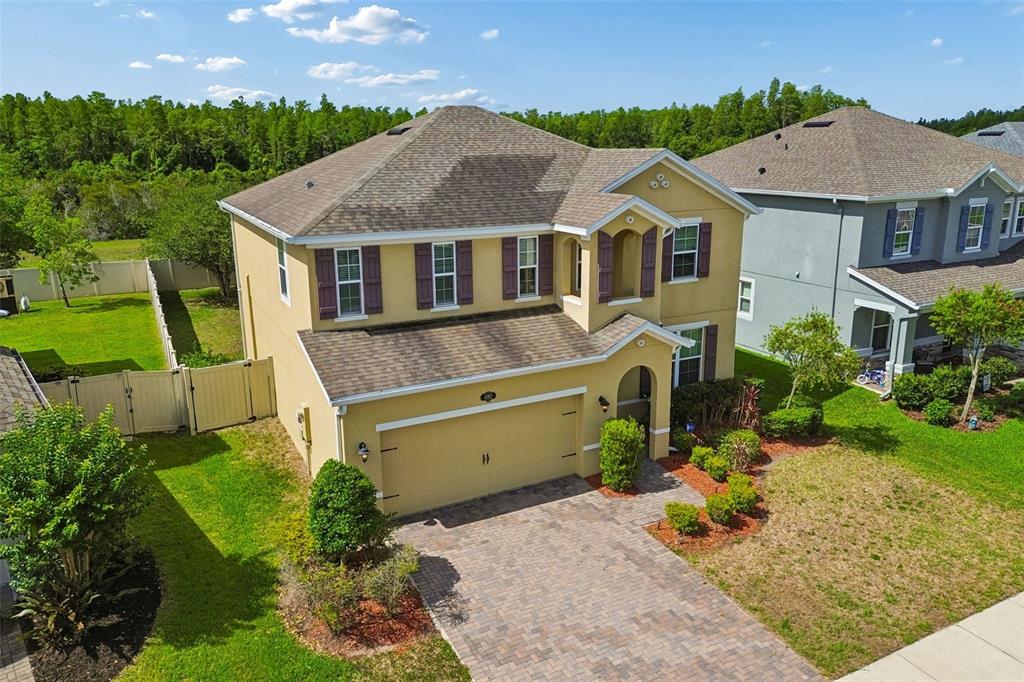 1192 Multiflora Loop Lutz, FL 33558 - Photo 2 of 32 a aerial view of a house with a yard table and chairs