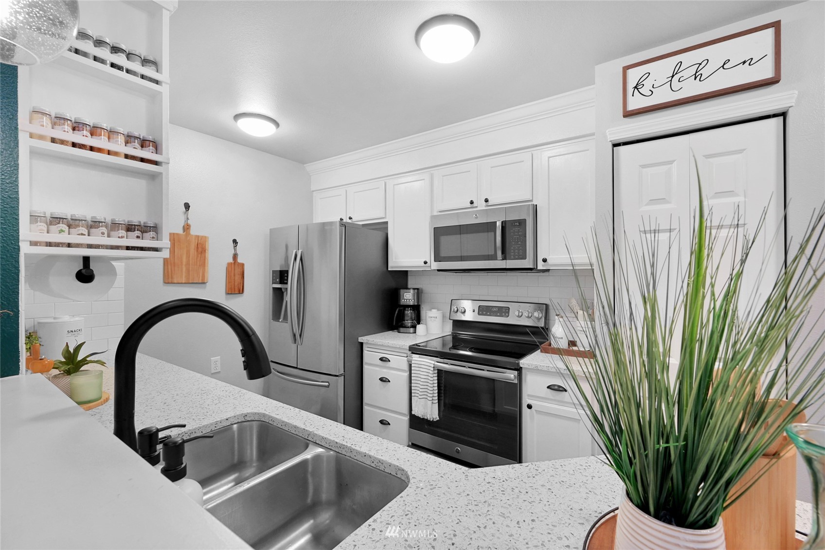 2201 192nd Street Southeast, Unit R103 Bothell, WA 98012 - Photo 7 of 29 a kitchen with stainless steel appliances a sink a microwave a refrigerator and a sink
