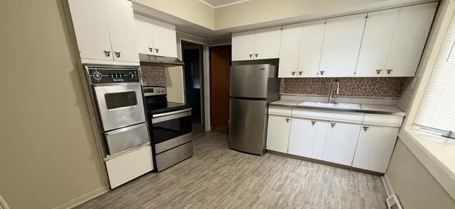a kitchen with a refrigerator sink and cabinets