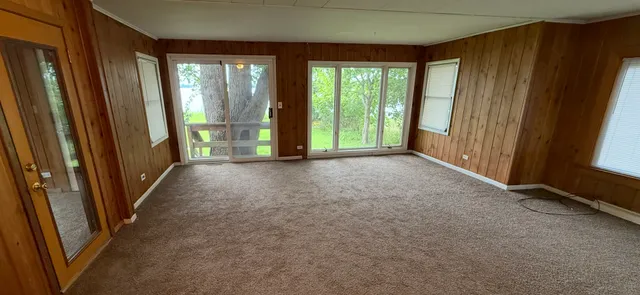 a view of a room with large windows and furniture