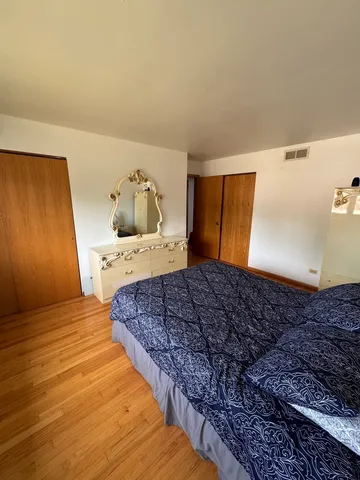 a spacious bedroom with a bed and dresser