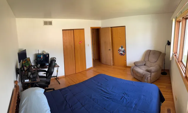 a bedroom with a bed and a large window