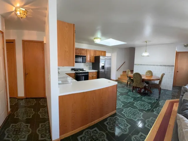 a living room with furniture a dining table and chairs with kitchen view
