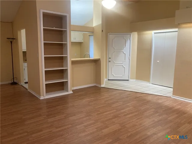 a view of an empty room with a closet and wooden floor