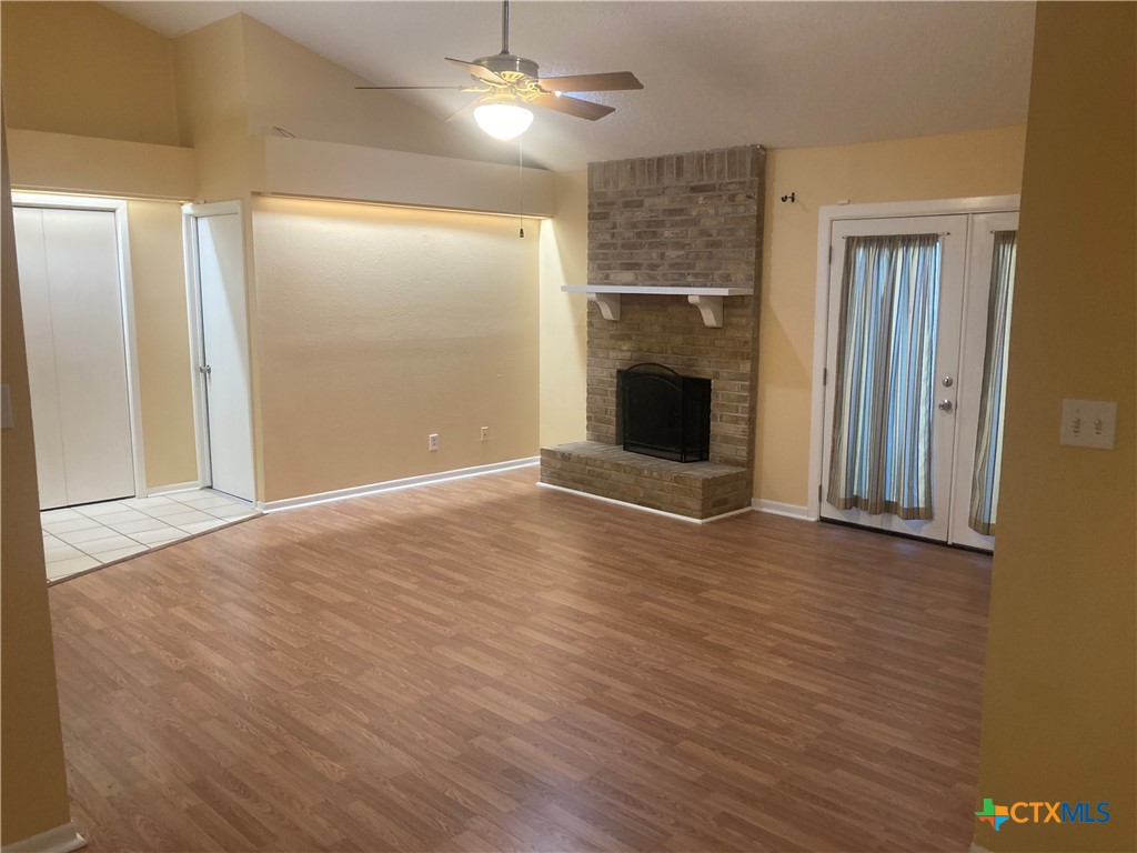 406 Rattan Drive Victoria, TX 77901 - Photo 4 of 15 an empty room with wooden floor fireplace and windows