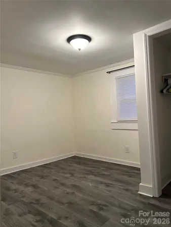 an empty room with wooden floor and mirror