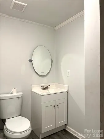 a bathroom with a toilet a sink a mirror and vanity
