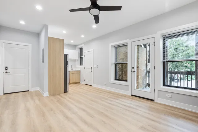 a view of a livingroom with a chandelier fan and windows