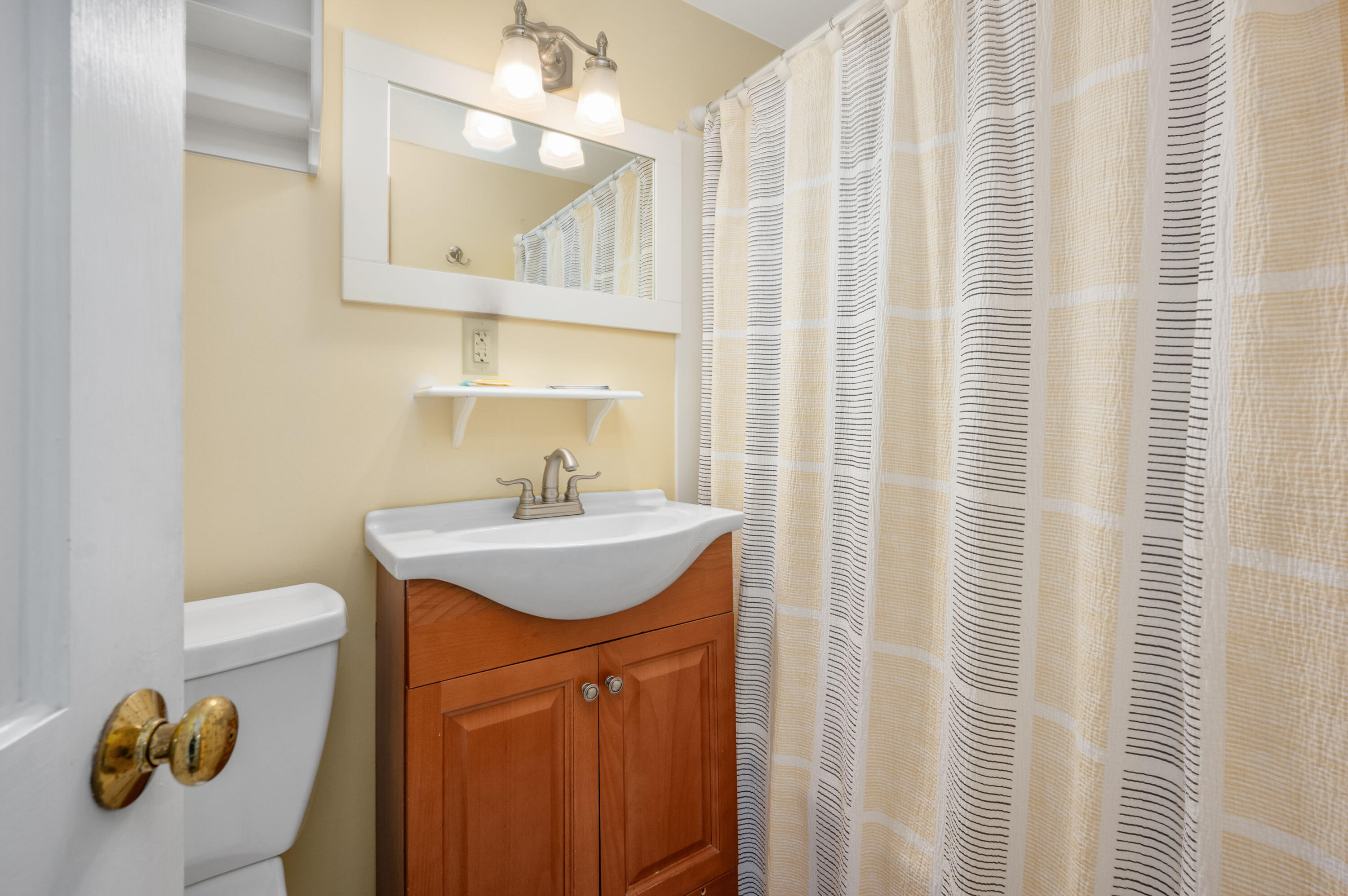 132 Shore Road, Unit 7 Truro, MA 02666 - Photo 11 of 24 a bathroom with a sink a toilet and shower curtain