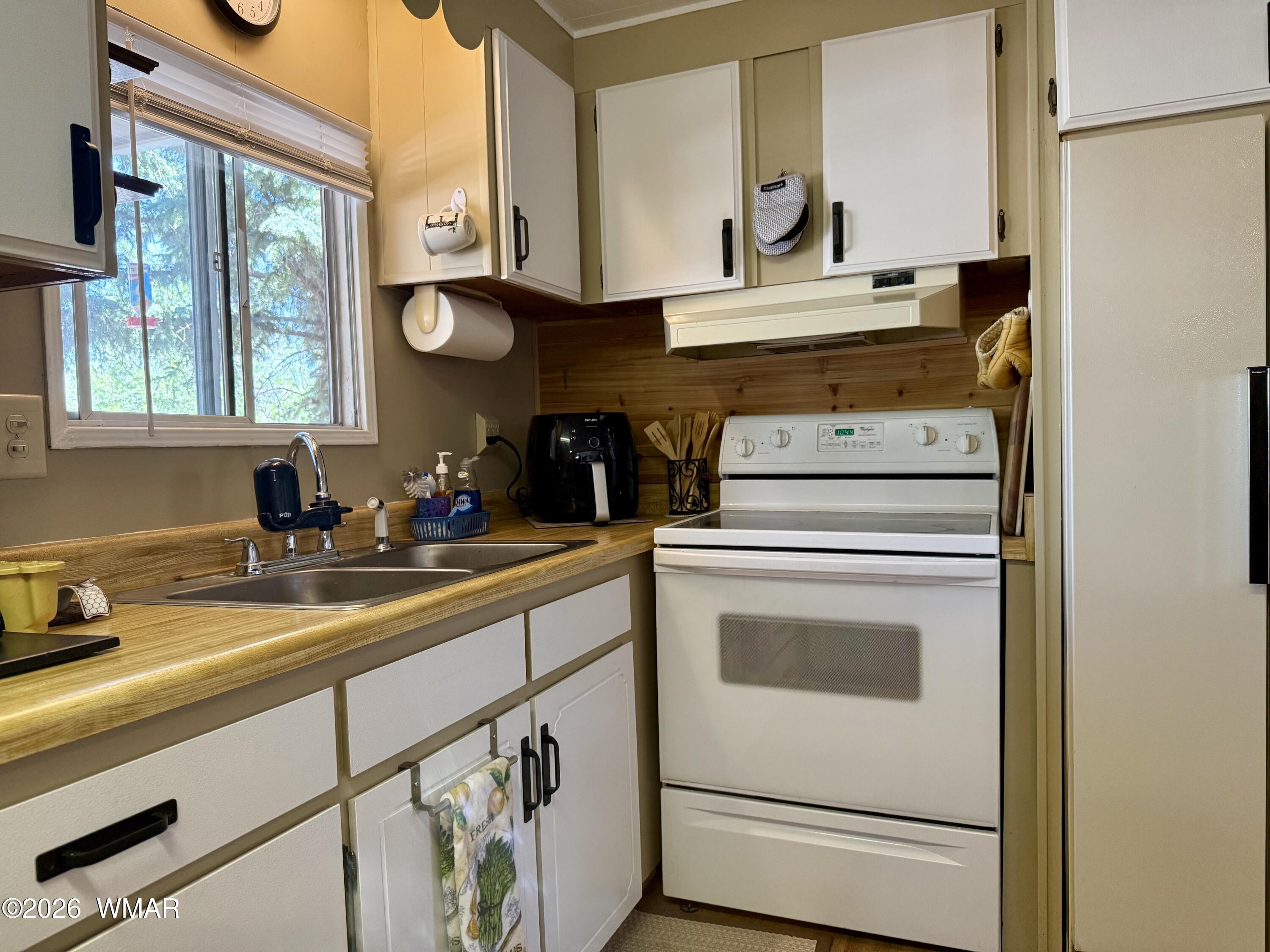 727 South Butler Street Eagar, AZ 85925 - Photo 6 of 32 a kitchen with a stove cabinets and a sink