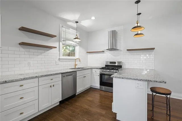 a kitchen with granite countertop cabinets a sink a window and stainless steel appliances